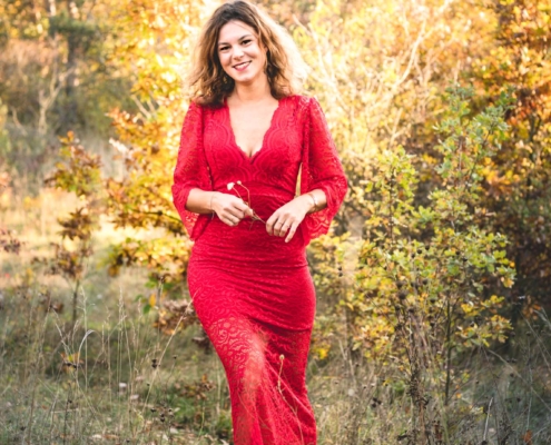 Porträt Hochformat, schöne Frau im roten Kleid, lächelnd, Zwischenmomente | Nina Hrusa Photography