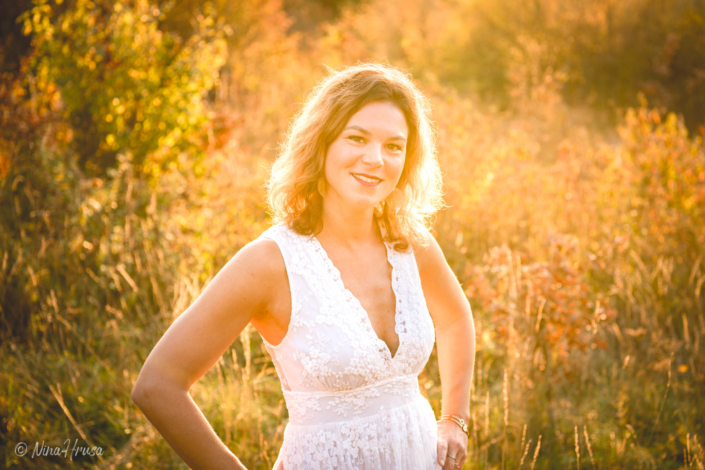 Gegenlicht Porträt Frau im weißen Boho Kleid stehend auf der Wiese, Sonnenuntergang, Zwischenmomente | Nina Hrusa Photography