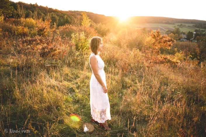 Porträt Frau im weißen Boho Kleid stehend auf der Wiese , Sonnenuntergang, Zwischenmomente | Nina Hrusa Photography