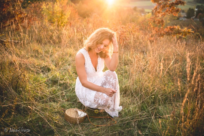 Porträt Frau im weißen Kleid auf der Wiese sitzend, Boho, Sonnenlicht, Zwischenmomente | Nina Hrusa Photography
