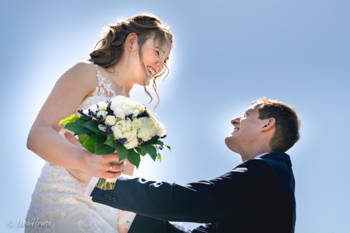 Bräutigam hebt lachende Braut mit Brautstrauß hoch, Hochzeitsfoto, Zwischenmomente | Nina Hrusa Photography