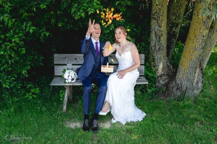 Brautpaar wirft Rosenblätter, Hochzeitsfoto, Zwischenmomente | Nina Hrusa Photography