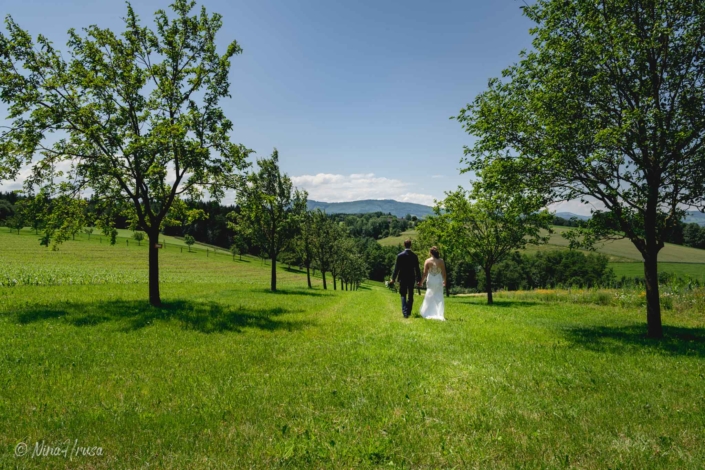 Brautpaar spaziert auf Wiese, Hochzeitsfotografie, Zwischenmomente | Nina Hrusa Photography