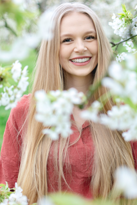 Mädchen lächelnd zwischen Kirschblüten, zauberhaftes Porträt, Zwischenmomente | Nina Hrusa Photography