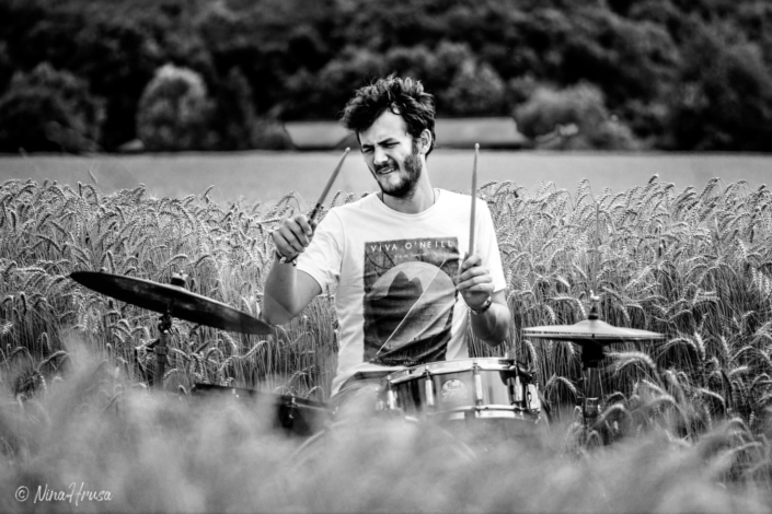 Porträt Mann am Schlagzeug im Feld, Drums in the field, playing, schwarzweiß, Black and white, Zwischenmomente | Nina Hrusa Photography