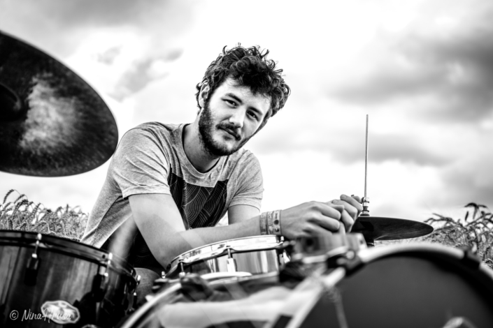 Porträt Mann am Schlagzeug im Feld, Schwarzweiss, Zwischenmomente | Nina Hrusa Photography