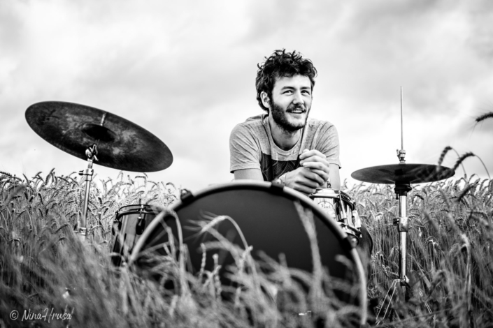 Mann am Schlagzeug im Feld, lachend, Zwischenmomente | Nina Hrusa Photography